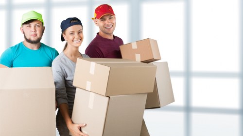 Removalists handling furniture and protective wrapping during a house move