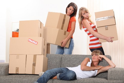 Removal crew handling household items with care during loading